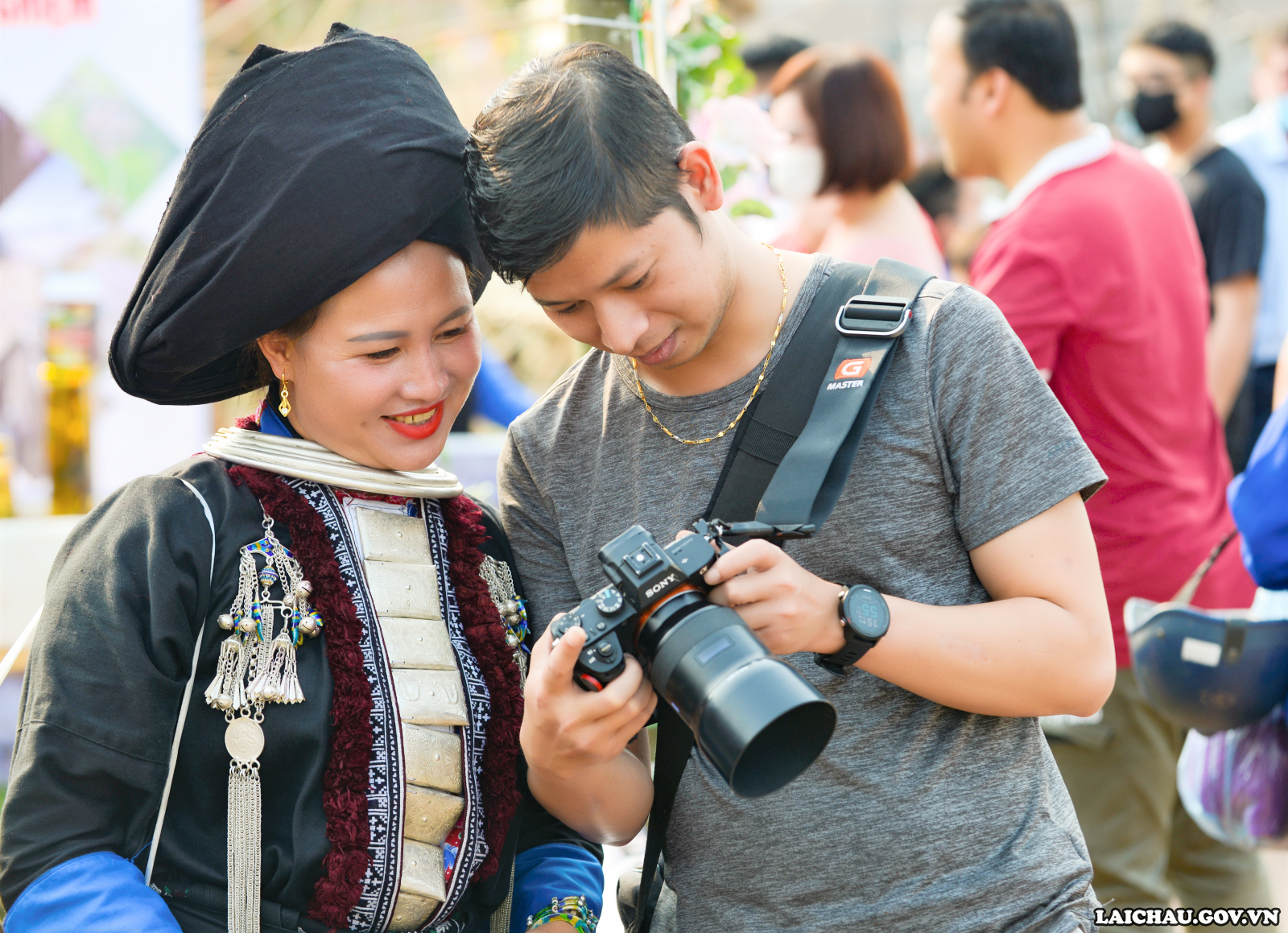 Phụ nữ Dao trong trang phục truyền thống cùng các nhiếp ảnh gia xem lại các bức ảnh tại lễ hội.
